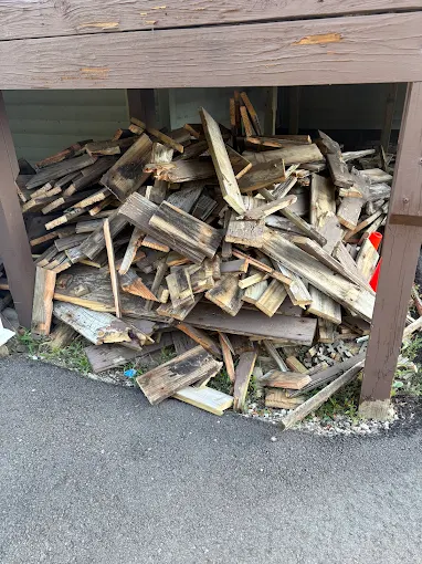 Pile of removed weathered deck boards beneath a raised deck