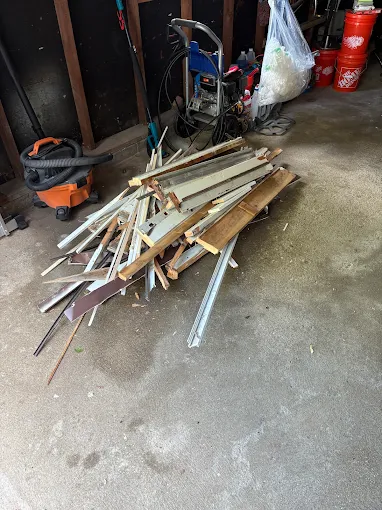 Pile of wood trim and metal renovation debris in a garage
